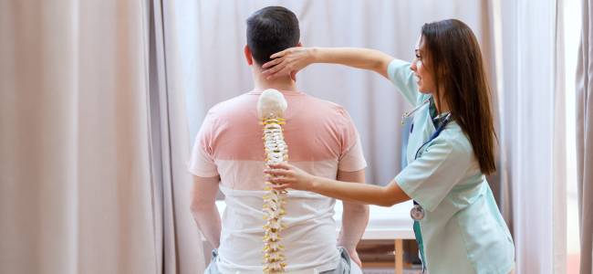 doctor holding a spine with patient