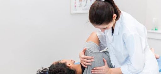 doctor helping patient with shoulder pain