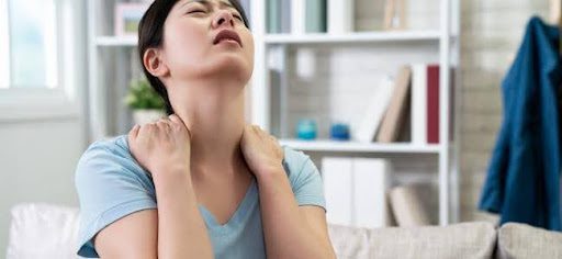 woman holding neck in pain