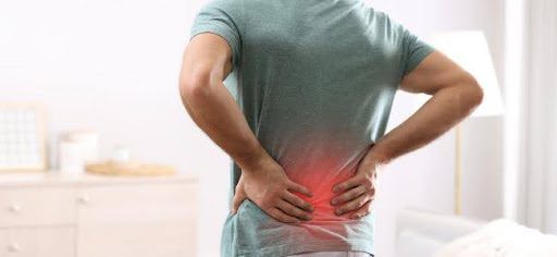 man with hands on lower back pain