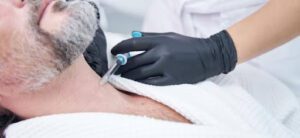 man with beard getting injection in his neck