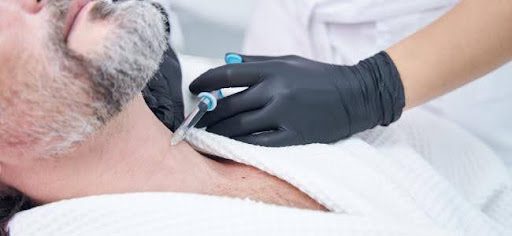 man with beard getting injection in his neck