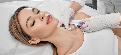 woman laying back getting injection in her neck