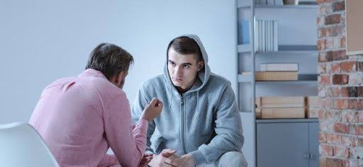 hooded man talking with other man