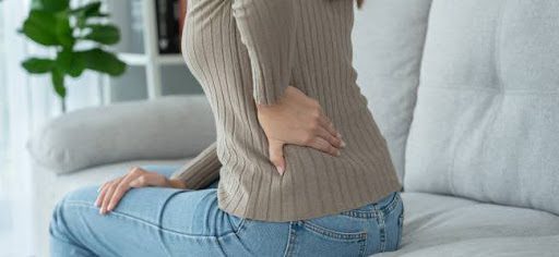 woman holding lower back pain