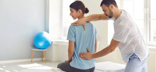 physical therapist helping womans back