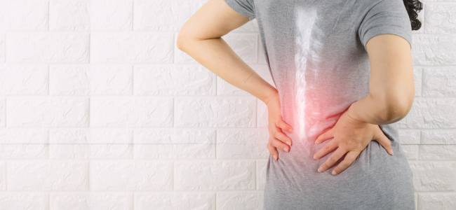 woman holding lower back in pain