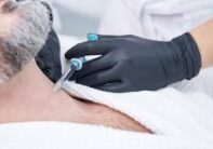 man with beard getting injection in his neck