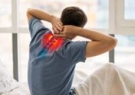 man with upper spine pain